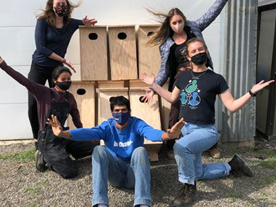 Interns showing off their newly built nesting boxes