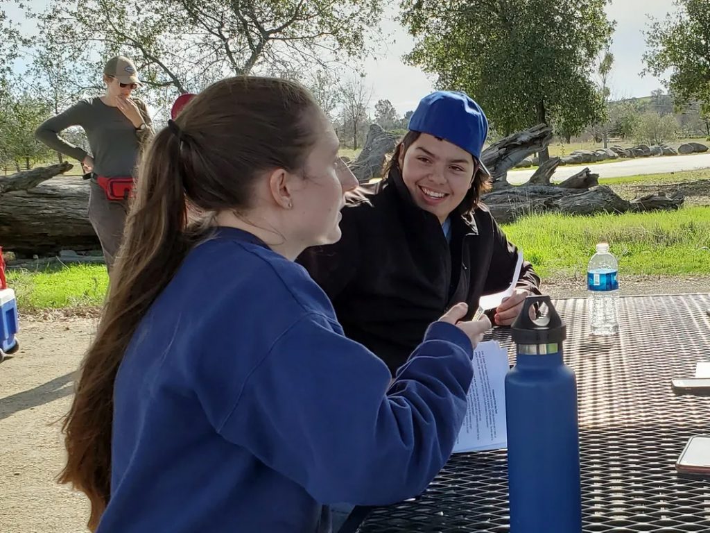 Students at an outdoor table during a SLEWS Planting Day event