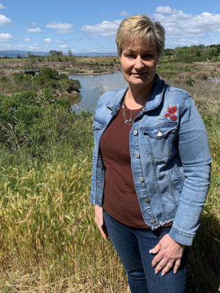 Sheila Pratt in a rose-embroidered denim jacket outdoors at the Nature Preserve