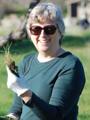 Sue McCloud in sunglasses holding plant plug