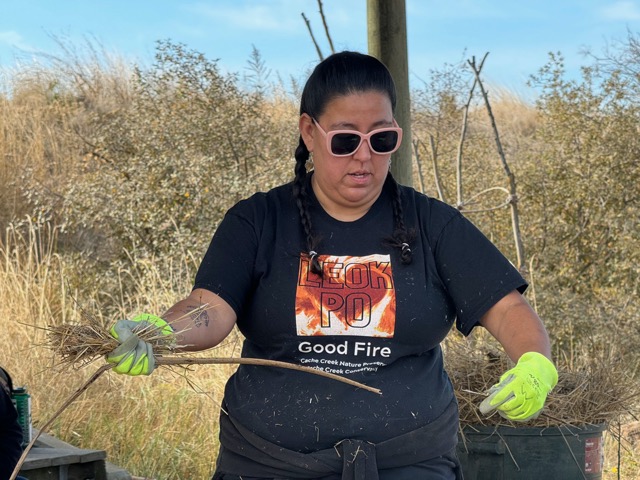 Chrissy Almendariz demonstrating how to wrap carrying torches at Leok Po 2023