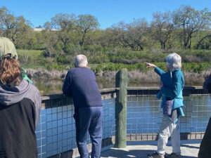 A group of people on the boardwalk overlooking the Nature Preserve wetlands